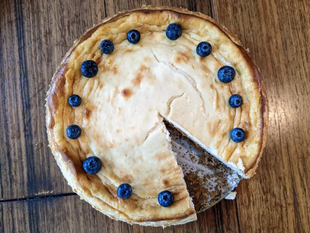 cheesecake with a slice missing and blueberries