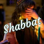 Woman has hands over her eyes and is saying the blessing over the Shabbat candles