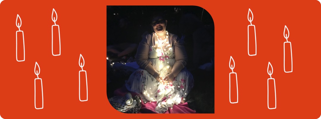 Photo of woman sitting while draped with lights in drawing with candles for Oy Vey 2023 Shabbat