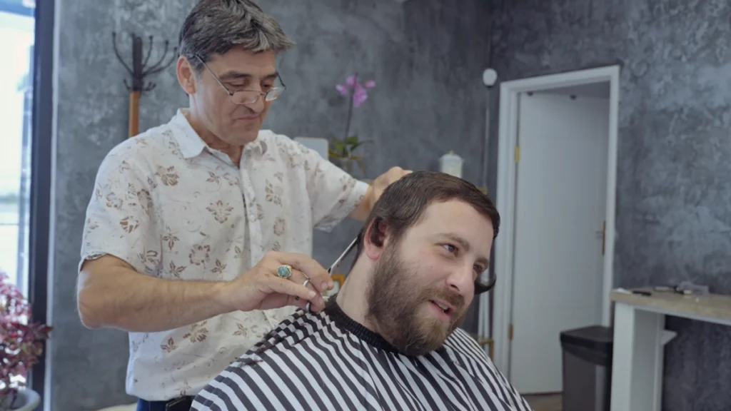 man in the barber in film Neighbours by Mano Khalil