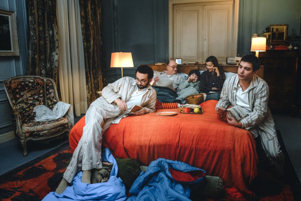 A group of people splayed out on a bed